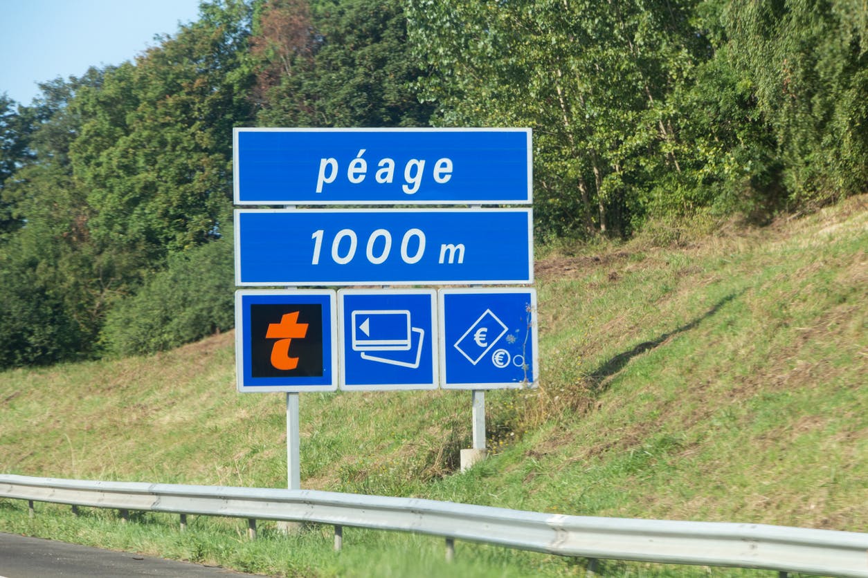 un panneau d'autoroute indiquant un péage à 1000m